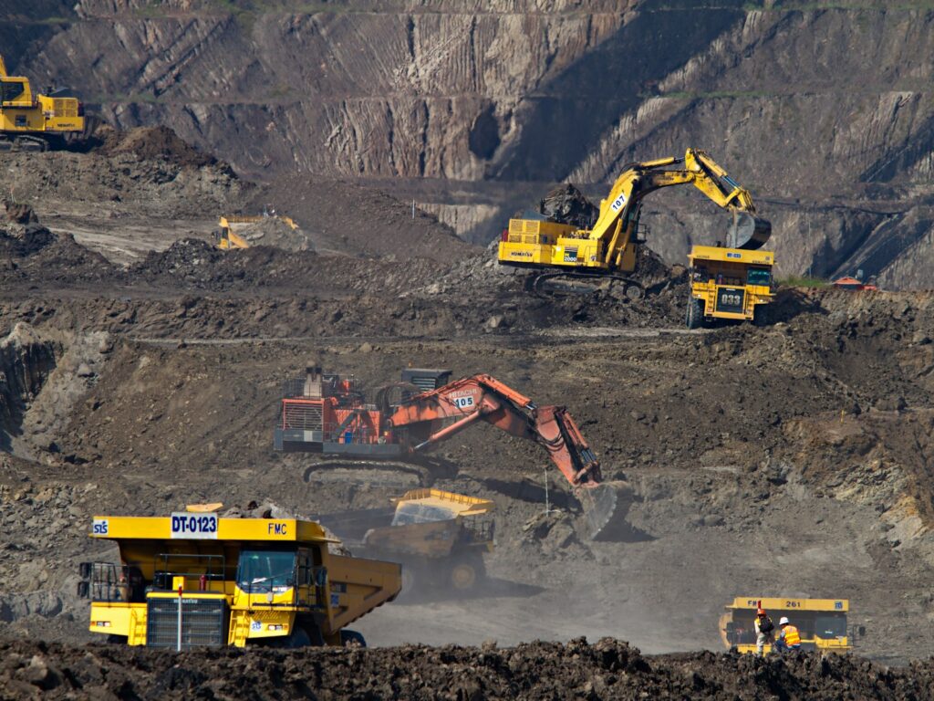 Excavators and haul trucks working in an open-pit mine